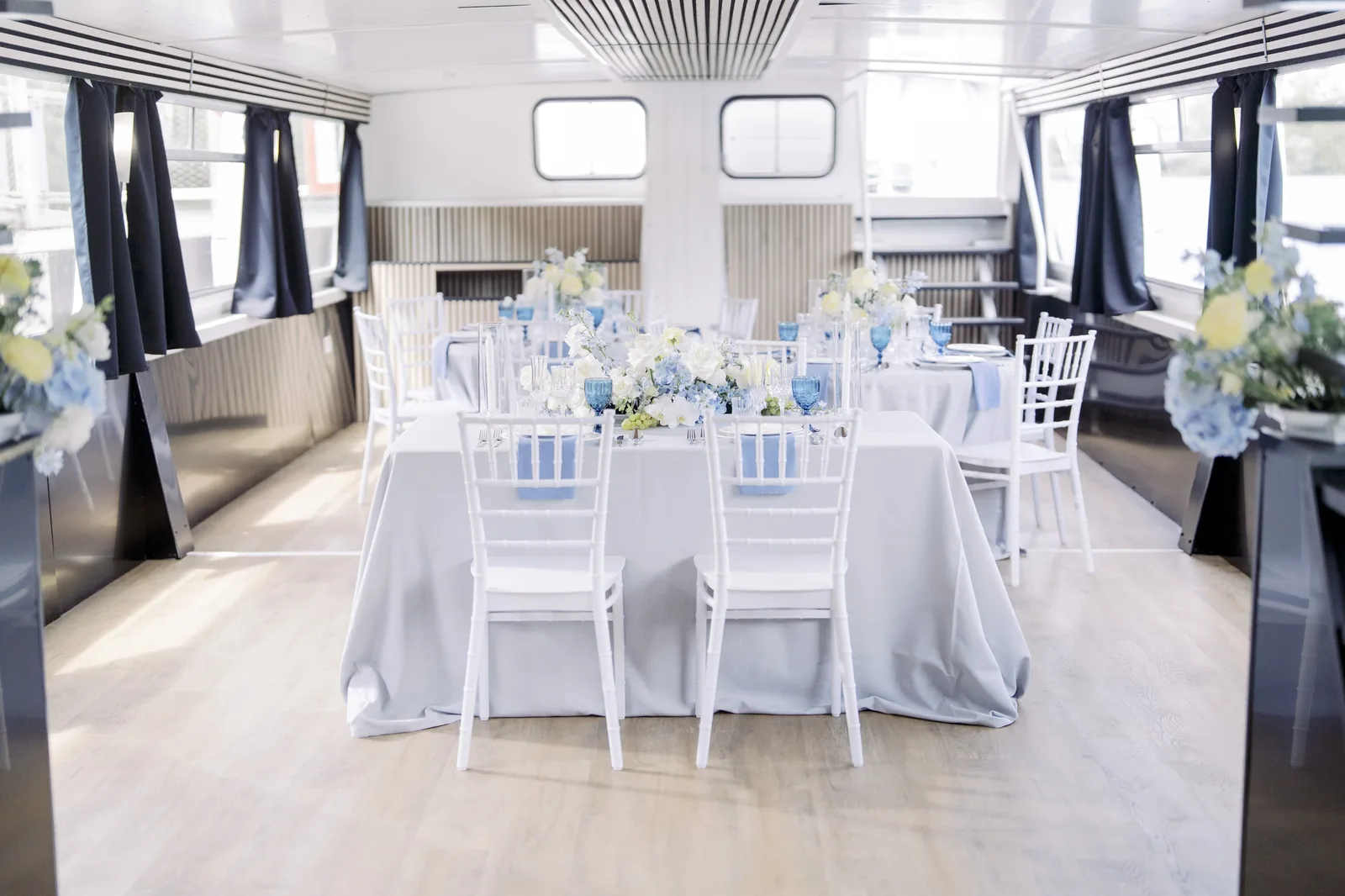 Salle du bateau Evana dressée en bleu et blanc pour un mariage